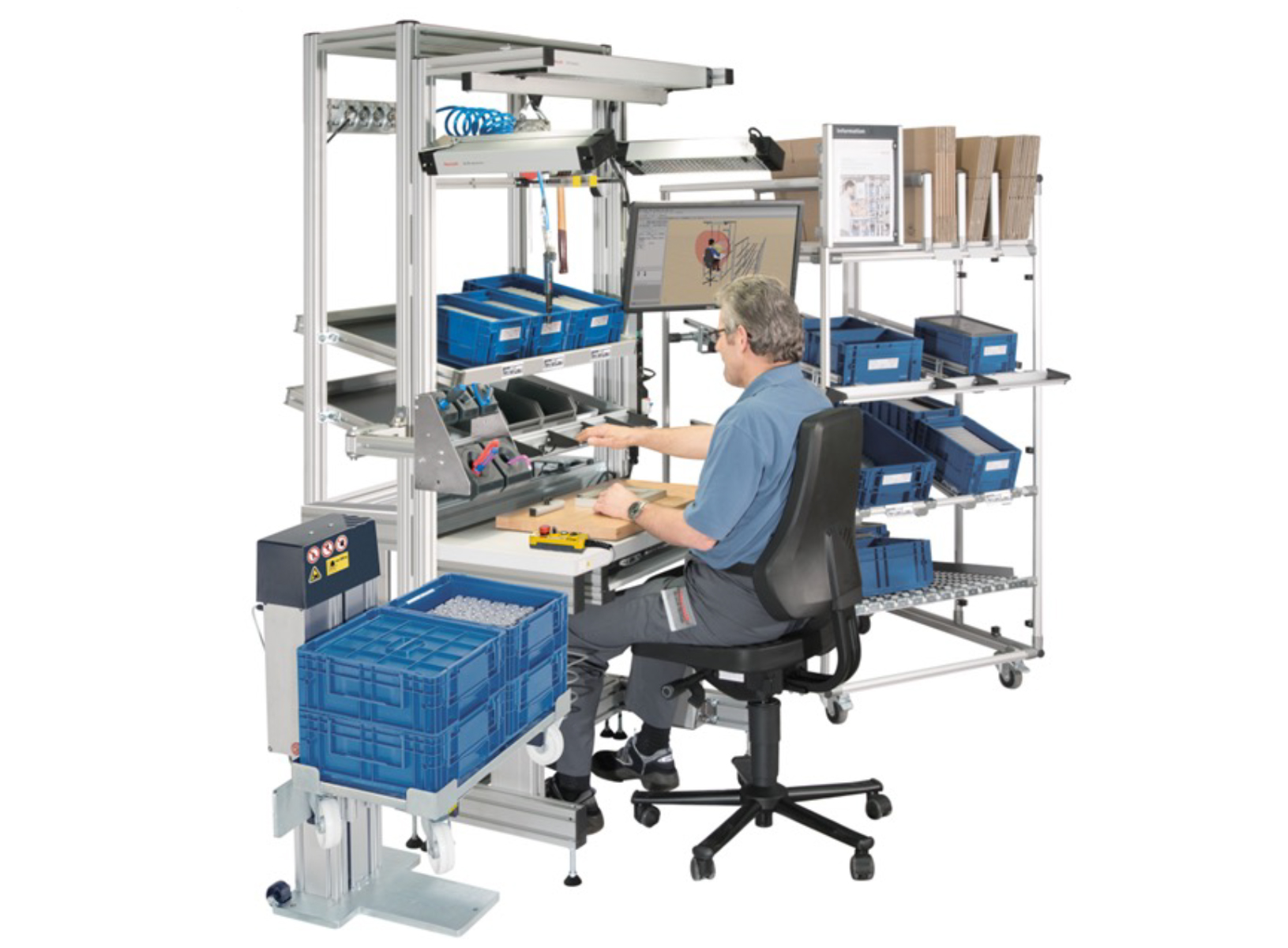 A person sits at an ergonomic workstation, surrounded by blue storage bins, tools, and dual monitors. The scene conveys a modern, organized workspace.